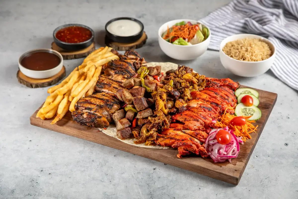 A mix grill platter laid out across a wooden board