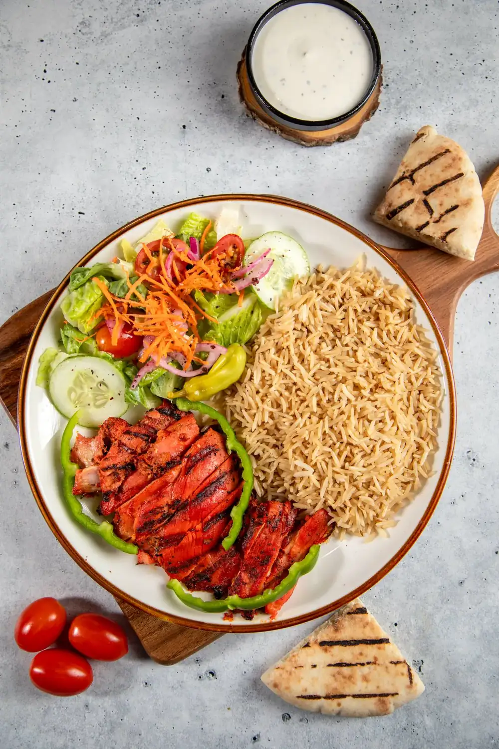 Tikka platter with rice, salad and pita