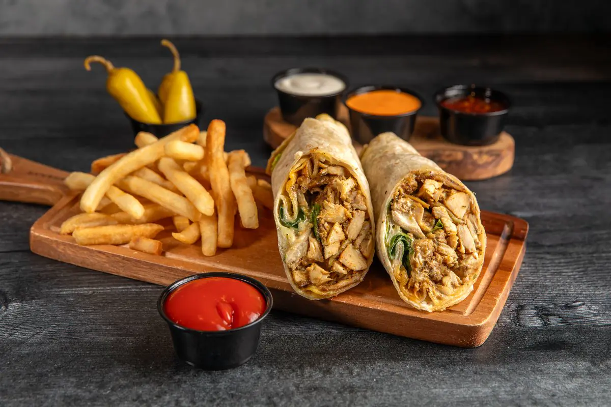 Chicken wraps cut open on a wooden board